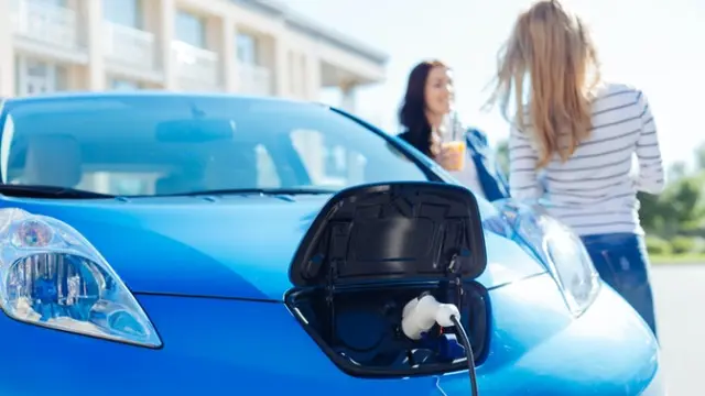 Blue electric car being charged